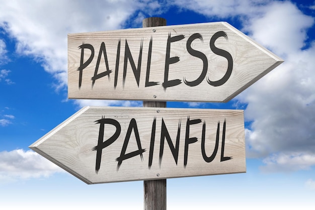 Painfull painless wooden signpost with two arrows and cloudy sky in background