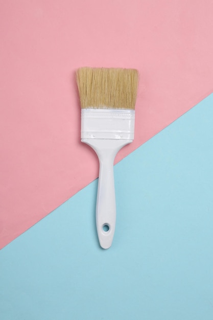 Paint brush on a bluepink pastel background Top view