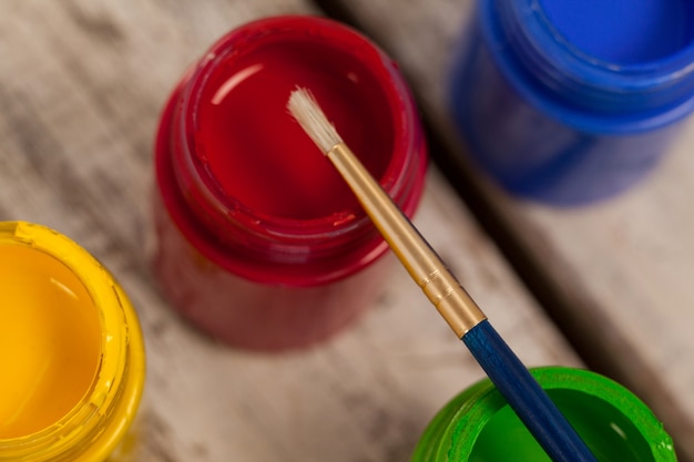 Paint brush on watercolor paints on wooden table