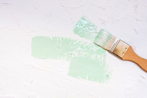 Paint Brush with color paint on white wall background