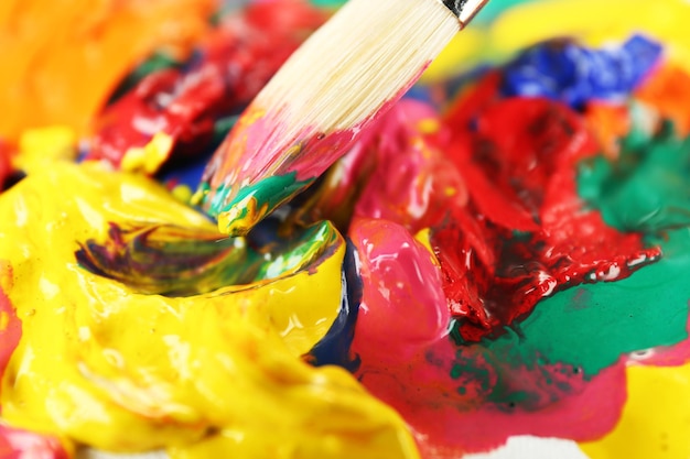 Paint brush with colorful paints close up