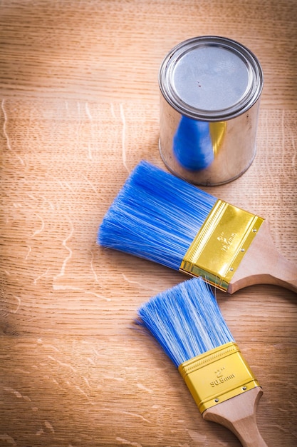 Paint brushes and can on wooden board