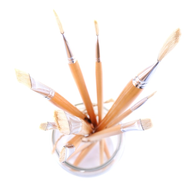 Paint brushes in glass jar isolated on white