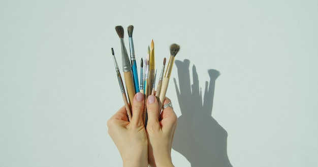 Paint brushes in the hand of painter