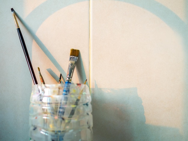 Paint brushes in old plastic cup