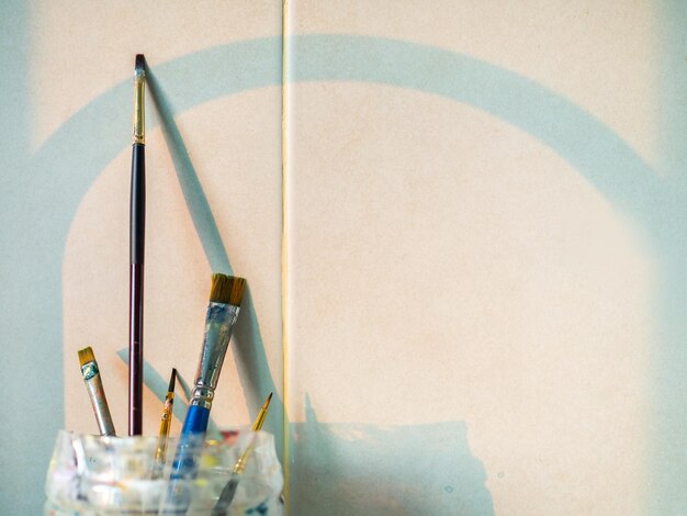 Paint brushes in old plastic cup