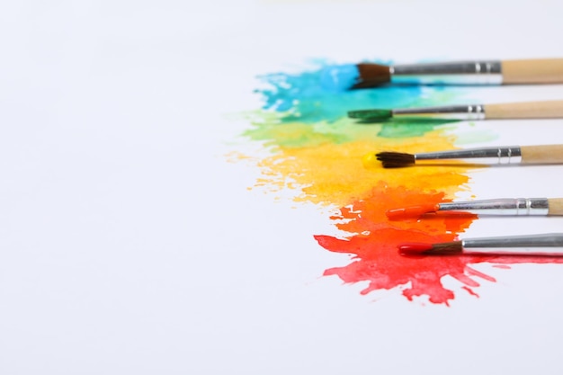 Paint brushes with paints on white background