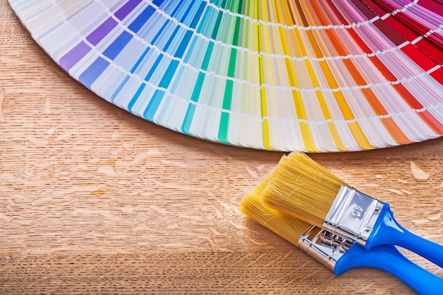 Paint brushes with pantone fan on wood board maintenance concept