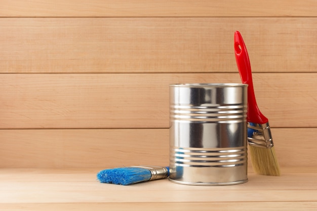 Photo paint bucket and paintbrush  on wooden background