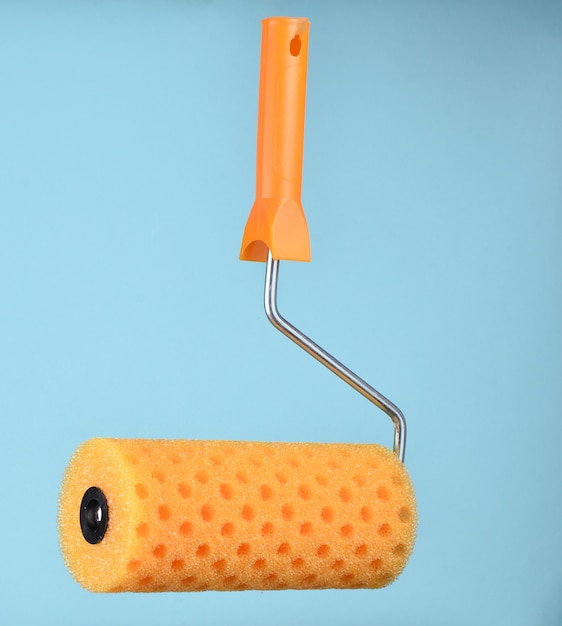 Paint roller on a blue background