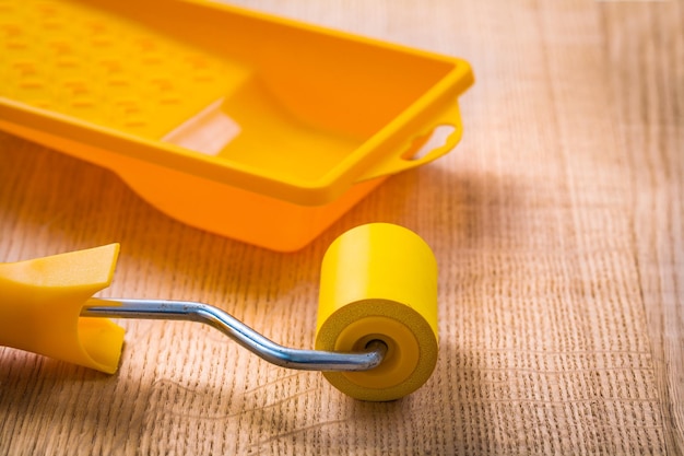 Paint roller and tray on wooden board