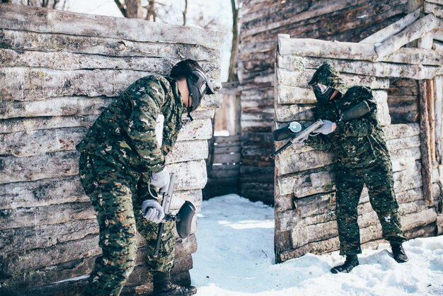 Paintball battle, paintballing in winter forest