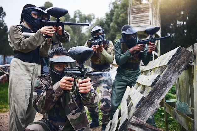Paintball militair team en schiettraining van vrienden en soldatengroep met geweer Doeloefening sportspel en wapensporten van legermannen in camouflage samen voor buitenspellen in uniform