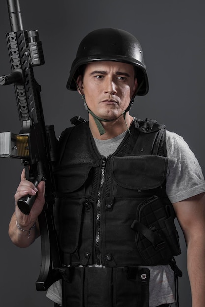 권총, 검은 갑옷 및 기관총을 목표로 보호 헬멧을 착용 페인트 볼 스포츠 선수