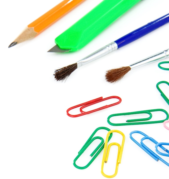 Paintbrush, paper clips and pencil isolated on white background