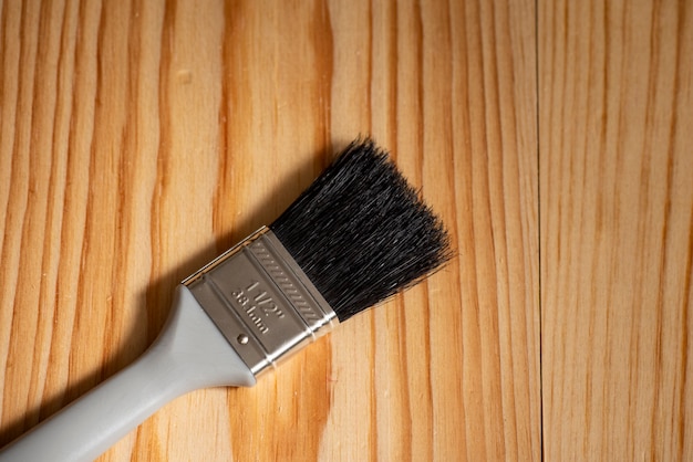 Photo paintbrush placed on a wooden surface and space for text to the side