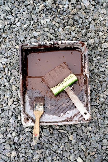 Photo paintbrushes in brown paint on wooden table top view copy space