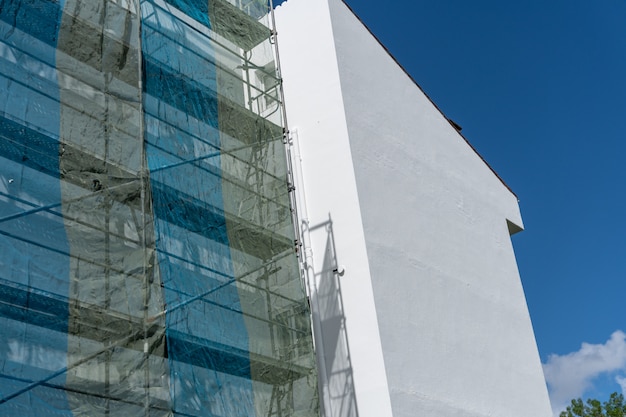 Painted building with metallic scaffolding wall