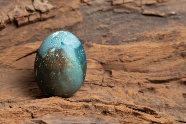 Foto uovo di pasqua dipinto su uno sfondo di corteccia di legno