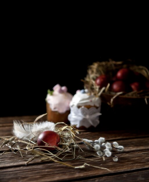 Foto uova di pasqua dipinte, salice e dolci pasquali. natura morta in stile vintage. messa a fuoco selettiva, profondità di campo