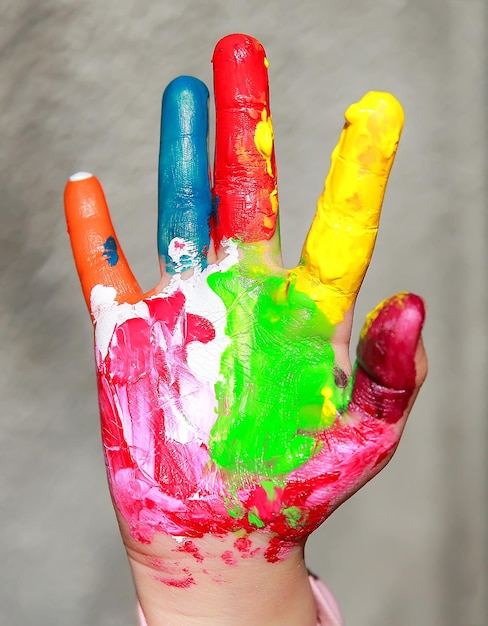 Photo painted kid hand isolated on grey background.