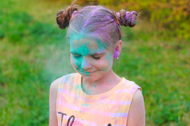 Painted portrait of young girl. Face with holi paint