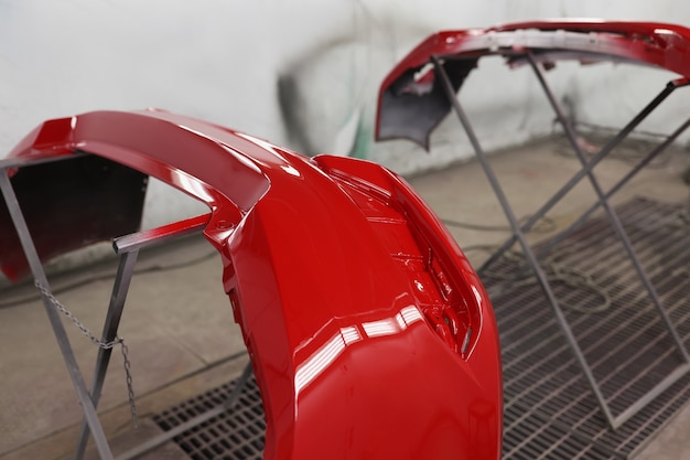 Painted red bumpers to drying in workshop closeup