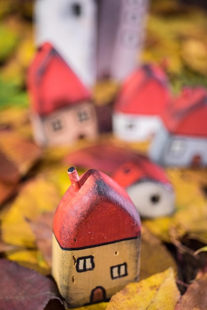 Painted toy houses on autumn leaves