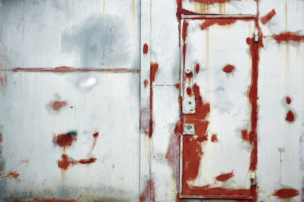 흰색과 빨간색 오래 된 손상 된 철 문 및 벽에 그린