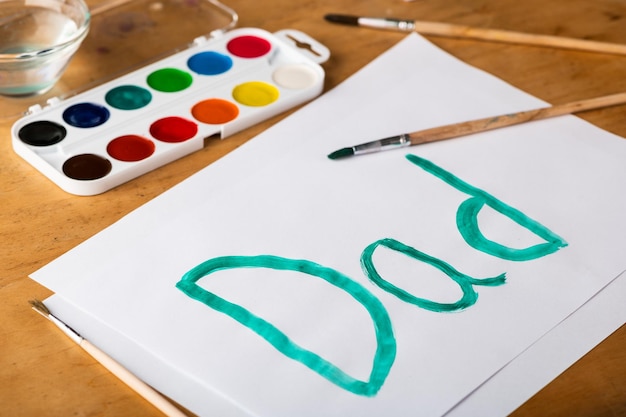 Painted word Dad with watercolors on white paper Father's Day and family concept