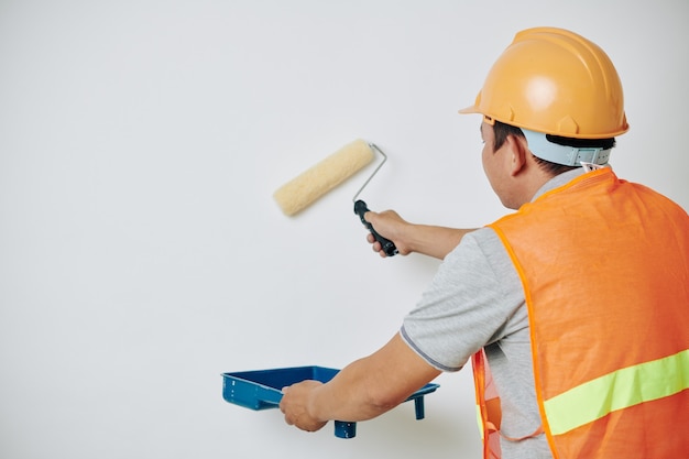 Painter applying white paint