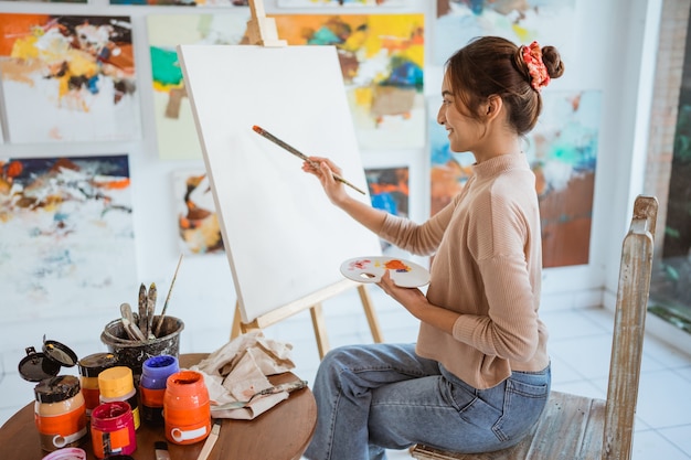 Painter artist painting on canvas shoot from her back