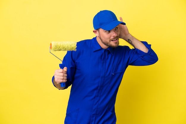Painter Brazilian man isolated on yellow background listening to something by putting hand on the ear