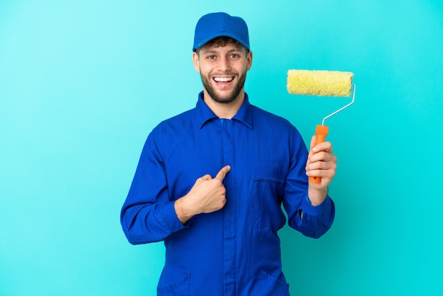 Painter caucasian man isolated on blue background with surprise facial expression