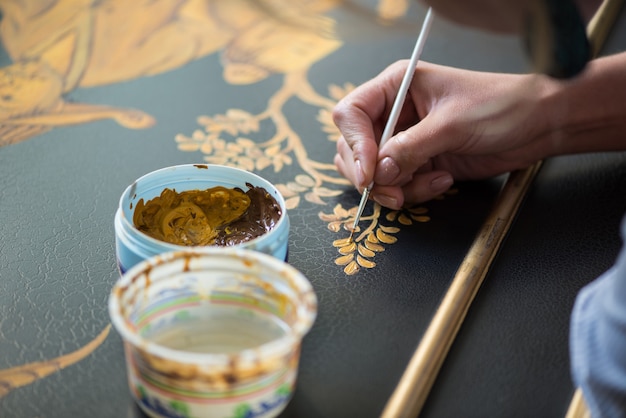 Photo painter decorator draws a pattern of tree and leaves