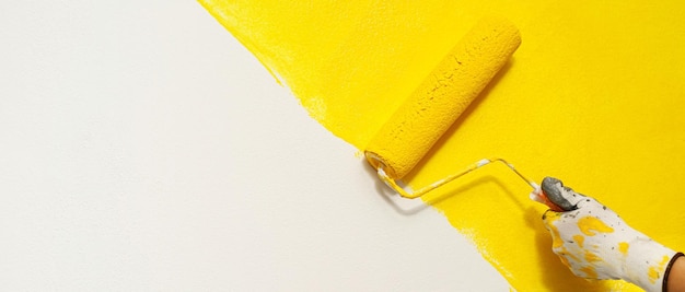 Художник красит внутреннюю стену в желтый цветx9