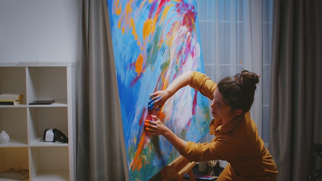 Художник делает шедевр своими пальцами в художественной студии для картинной галереи.
