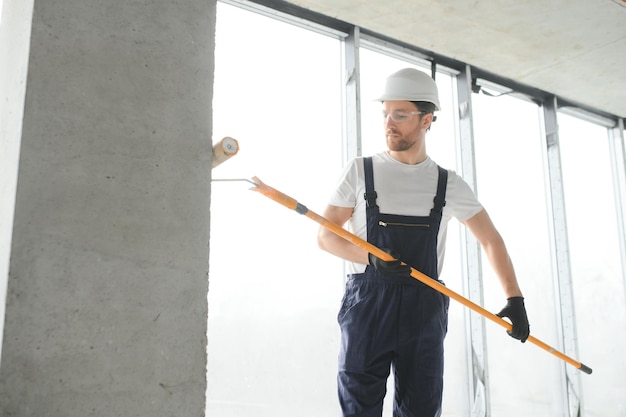 Painter man painting the wall with paint roller