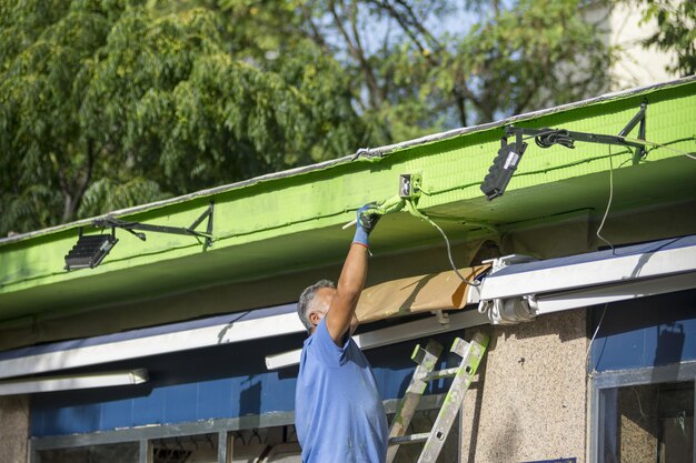 Photo painter man at work wall painting green color ecological concept