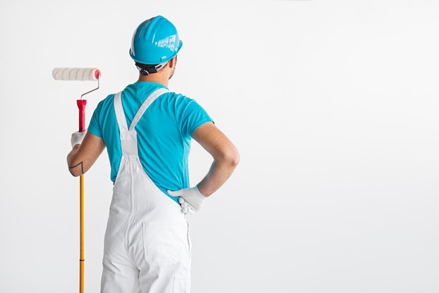 Painter in overalls with roller