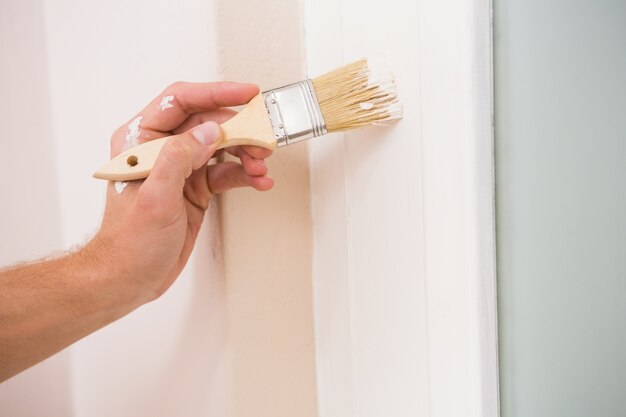 Painter painting the door white