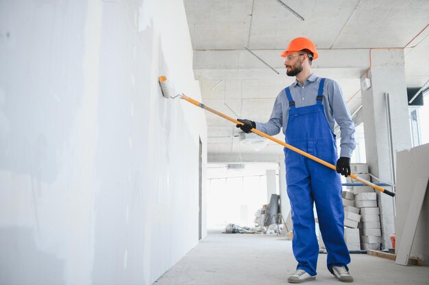 Photo painter in uniform paints the wall