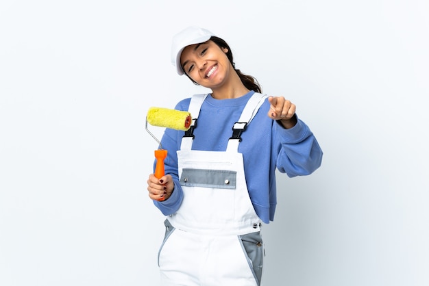 Painter woman over isolated white background pointing front with happy expression