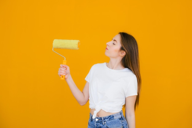 Painter women at work with roller painting wall painter house\
concept