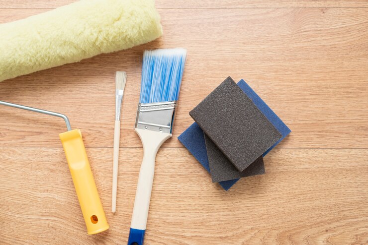 Painting brushes and rollers on wooden background. Building tools for painting surfaces