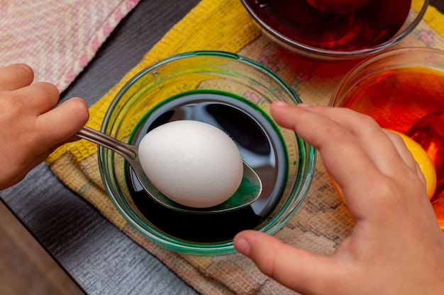 Painting, dying green Easter eggs in glass jar