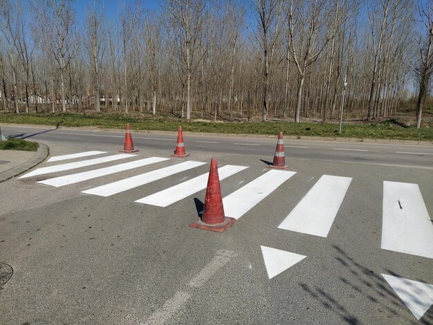 Painting pedestrian crossings with new paint road warning plastic orange cone white stripes on the