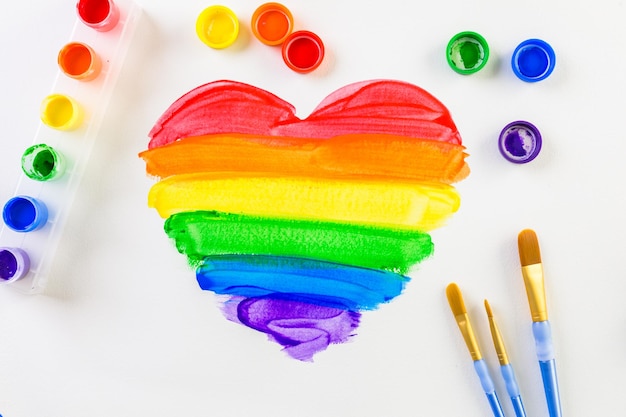 painting rainbow gay pride heart on a white paper.
