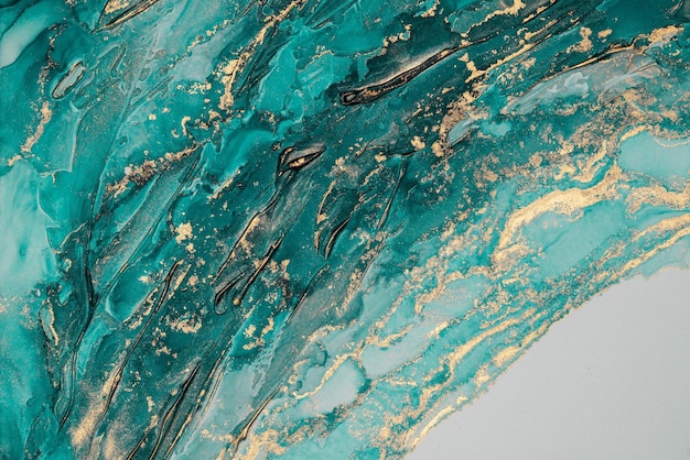 A painting of a turquoise wave with gold paint on it.