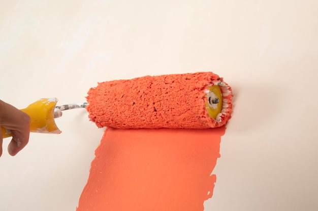 Painting the wall orange color paint roller